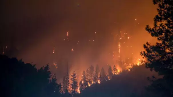 A home burns on Jeters Road as the Dixie Fire jumps Highway 395 south of Janesville, Calif., on Monday. Critical fire weather throughout the region threatens to spread the multiple wildfires burning in Northern California. (Ethan Swope/AP)