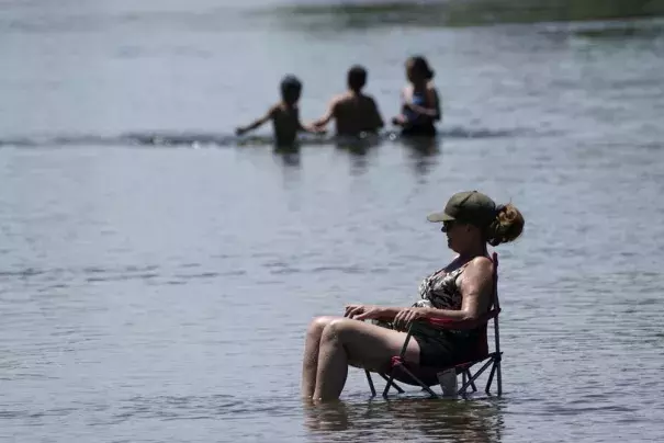 Dianna Andaya, relaxes in the cooling water of the American River as the temperature climbed over the 100 degree mark in Sacramento, Calif., Friday, June 10, 2022. Forecasters are warning of dangerously high temperatures in much of the interior of California as high pressure grips the region. (Credit: AP Photo/Rich Pedroncelli)