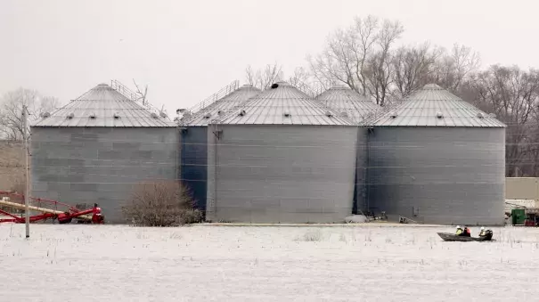 Utility workers travel by boat past grain bins in the flooded town of Pacific Junction, Iowa, Wednesday, April 3, 2019. Several communities along the Missouri River continue to struggle to restore drinking water service weeks after massive flooding disrupted life in the towns and caused significant damage. Photo: Nati Harnik, Associated Press