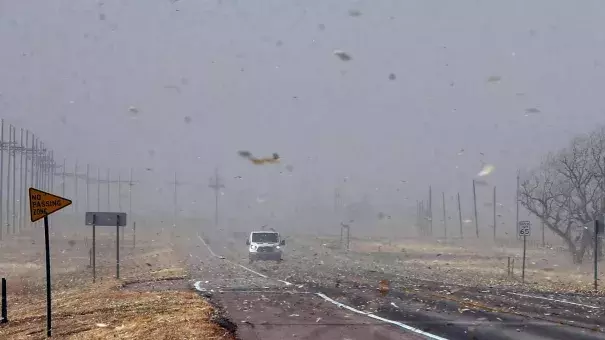 Debris from nearby farm fields swirls around on Highway 400 between Mullinville, Kansas, and Dodge City. (Credit: Travis Heying/The Wichita Eagle (AP))