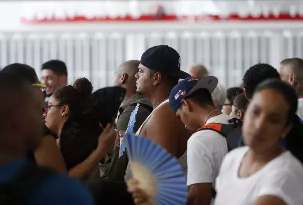 People wait in line for a flight out in a sweltering San Juan Airport in San Juan, Puerto Rico on Sept. 29, 2017. (Credit: Jessica Rinaldi/The Boston Globe via Getty Images)