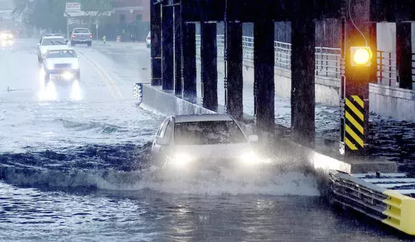 A car is partially submerged as it travels beneath a railroad underpass in Fort Wayne, Ind., on Thursday, May 25, 2017, following heavy rains that sparked flash flooding in the northeastern Indiana city. Photo: Samuel Hoffman, The Journal-Gazette via AP