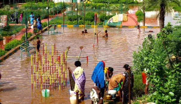 Children using a flooded playground as a swimming pool in Chennai. Photo: Ben Robinson