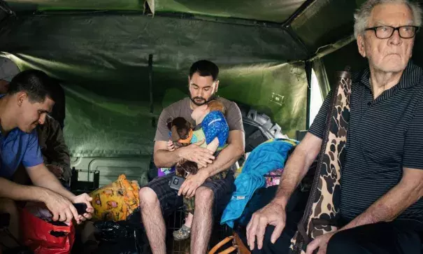 Aaron Elizade, center, holds his nephew Landon Schumaker, 2, on Tuesday after evacuating an apartment complex in west Houston. Photo: Alyssa Schukar, The New York Times