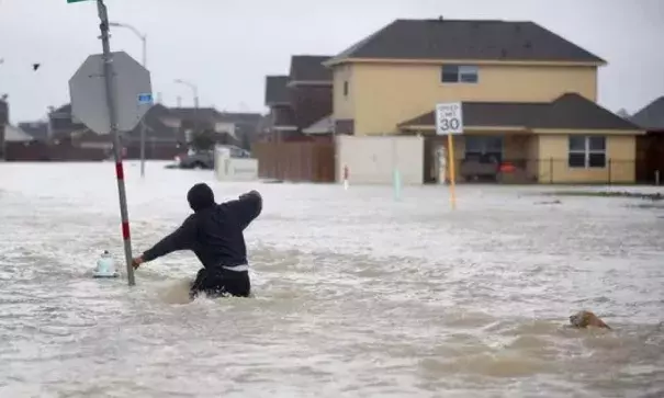 A person walks through a flooded street with a dog after the area was inundated with flooding from Hurricane Harvey on August 28, 2017 in Houston, Texas. Photo: Joe Raedle, Getty Images