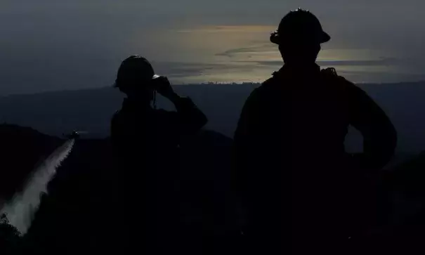 Santa Barbara County firefighters stand on Gibraltar Ridge, located above Santa Barbara and Montecito, as a water drop is made on the Thomas fire on Monday. Photo: Mel Melcon, Los Angeles Times