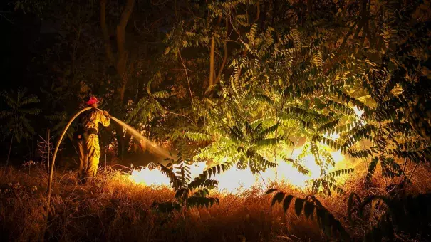 A firefighter works to defend structures on Lytle Creek Road on Wednesday night. Photo: Marcus Yam / Los Angeles Times