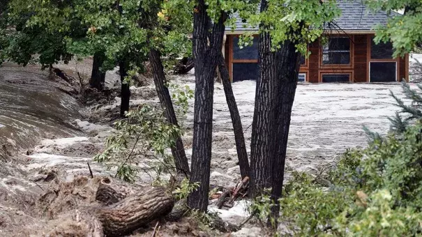 A torrent of water rushes alongside a swamped house following flash flooding near Left Hand Canyon, south of Lyons, Colo., Sept 12, 2013. Photo: Brennan Linsley, AP