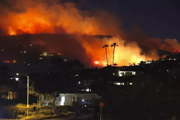 A wildfire burns early Thursday, Feb. 10, 2022, in the Emerald Bay Area near Laguna Beach, Calif. A wildfire fanned by gusty Santa Ana winds erupted in hills on the Southern California coast early Thursday but firefighters kept flames from damaging homes and after several hours officials were optimistic the blaze could be stopped. (Credit: @dustyschuh via AP)